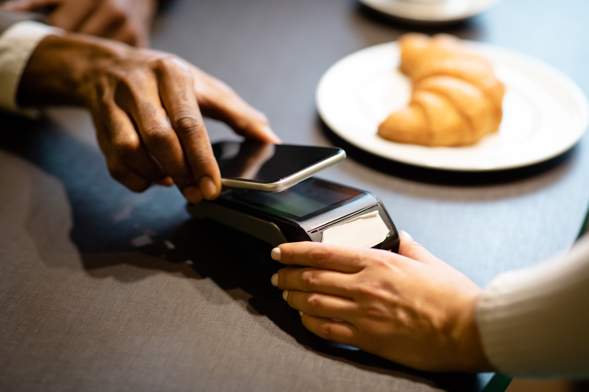 afro-businessman-paying-with-his-cellphone-at-the-bar.jpg